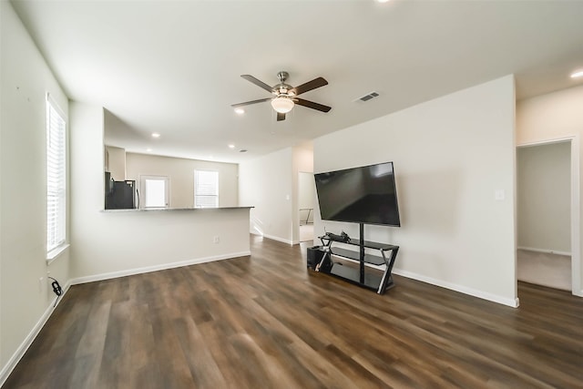 unfurnished living room with ceiling fan, plenty of natural light, and dark hardwood / wood-style floors