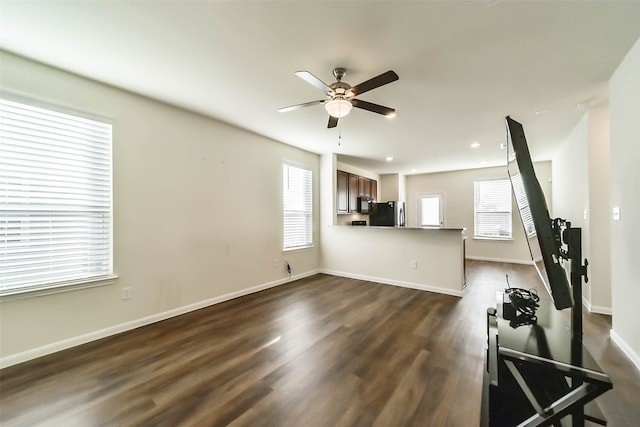 unfurnished living room with a wealth of natural light, dark hardwood / wood-style flooring, and ceiling fan