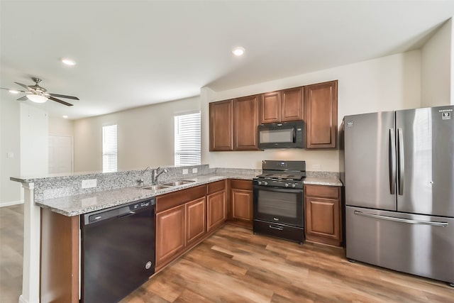 kitchen featuring ceiling fan, sink, dark hardwood / wood-style flooring, kitchen peninsula, and black appliances