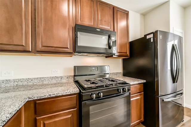 kitchen featuring light stone counters and stainless steel appliances