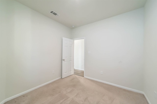 unfurnished room featuring light carpet