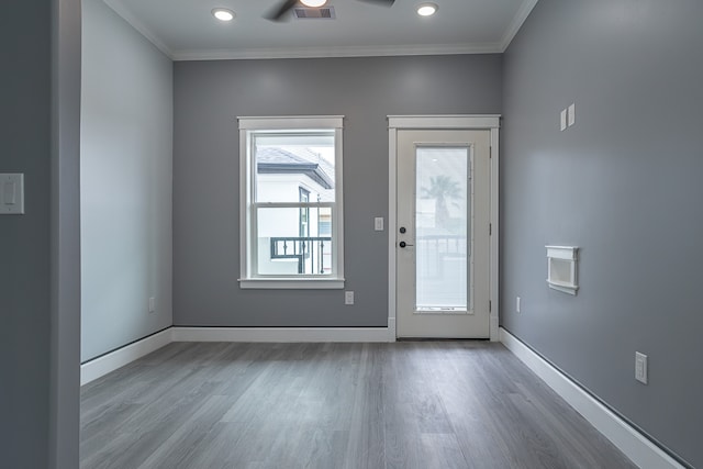 doorway with ceiling fan, light wood-type flooring, and crown molding