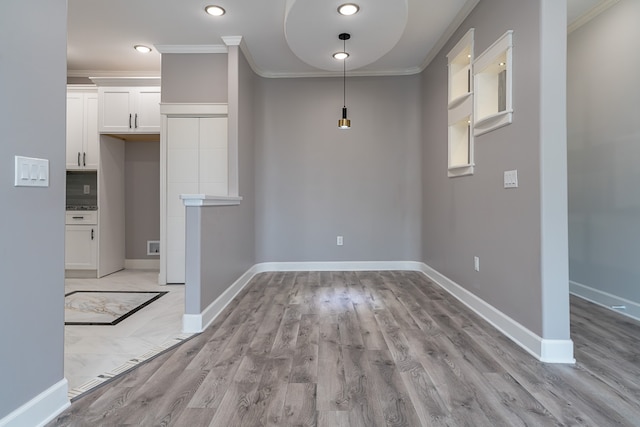 unfurnished dining area with light hardwood / wood-style floors and crown molding