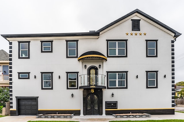 view of front of house featuring a balcony and french doors