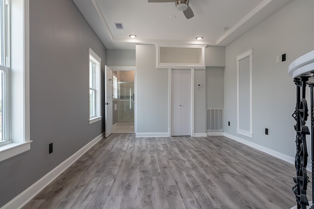 unfurnished bedroom with multiple windows, ceiling fan, and light wood-type flooring