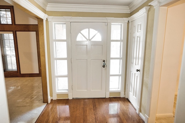 foyer featuring hardwood / wood-style flooring, a wealth of natural light, crown molding, and decorative columns