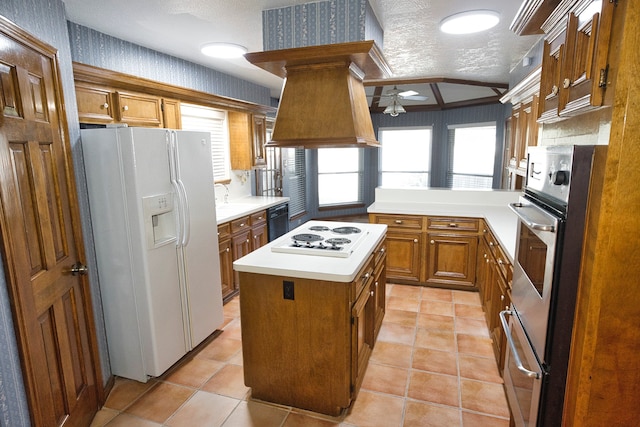 kitchen featuring white appliances, crown molding, ceiling fan, a textured ceiling, and a kitchen island