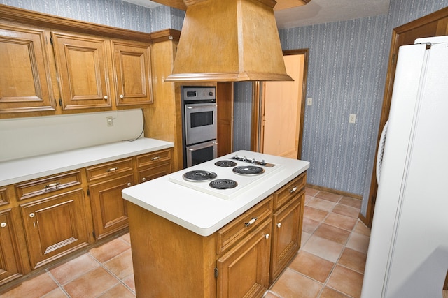 kitchen featuring light tile patterned floors, white appliances, premium range hood, and a center island