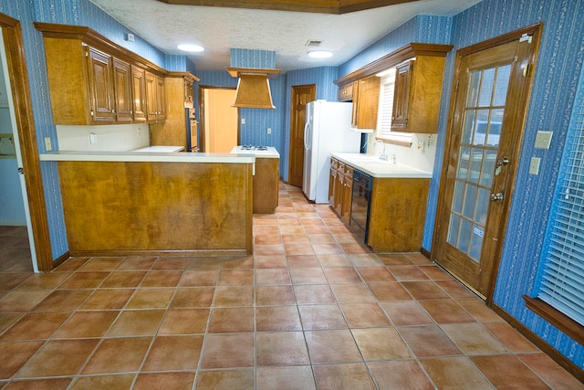 kitchen with white refrigerator, sink, a textured ceiling, black dishwasher, and kitchen peninsula