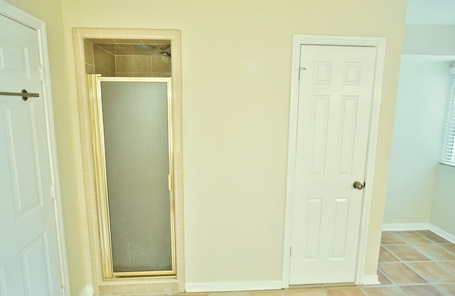 bathroom with tile patterned flooring and a shower with door