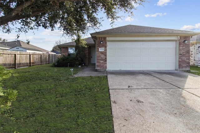 single story home with a garage and a front lawn