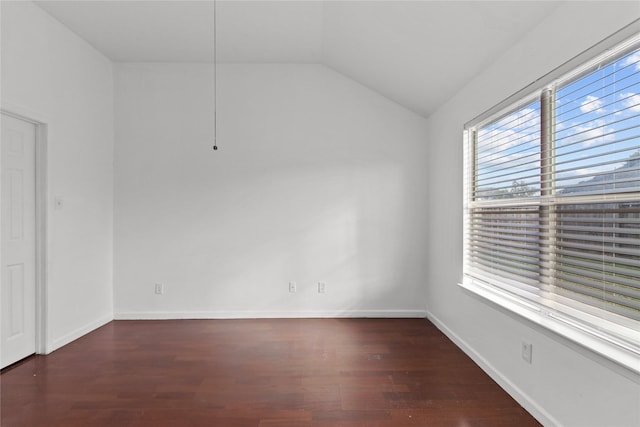 spare room featuring dark hardwood / wood-style floors and lofted ceiling