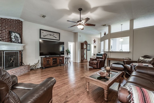 living room featuring hardwood / wood-style floors, ceiling fan, and a brick fireplace