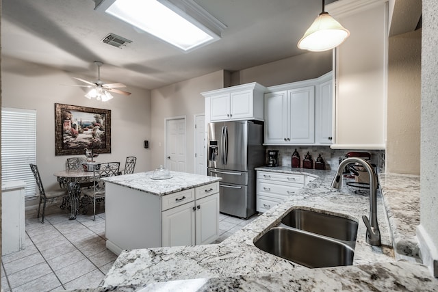 kitchen featuring white cabinetry, sink, ceiling fan, stainless steel fridge with ice dispenser, and pendant lighting