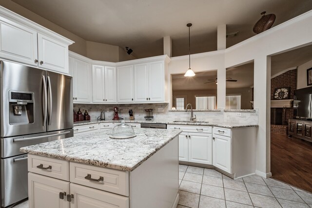 206 Private Road 635, Dayton, TX 77535 - kitchen with appliances with stainless steel finishes, a sink, backsplash, a kitchen island, and light tile patterned floors