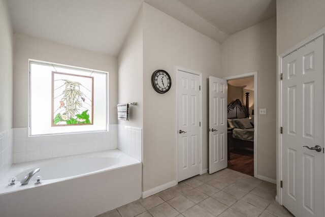 206 Private Road 635, Dayton, TX 77535 - ensuite bathroom with tile patterned flooring, a garden tub, baseboards, and vaulted ceiling