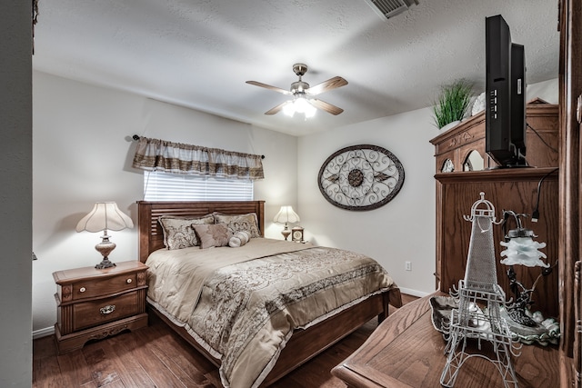 bedroom featuring ceiling fan, dark hardwood / wood-style floors, and a textured ceiling