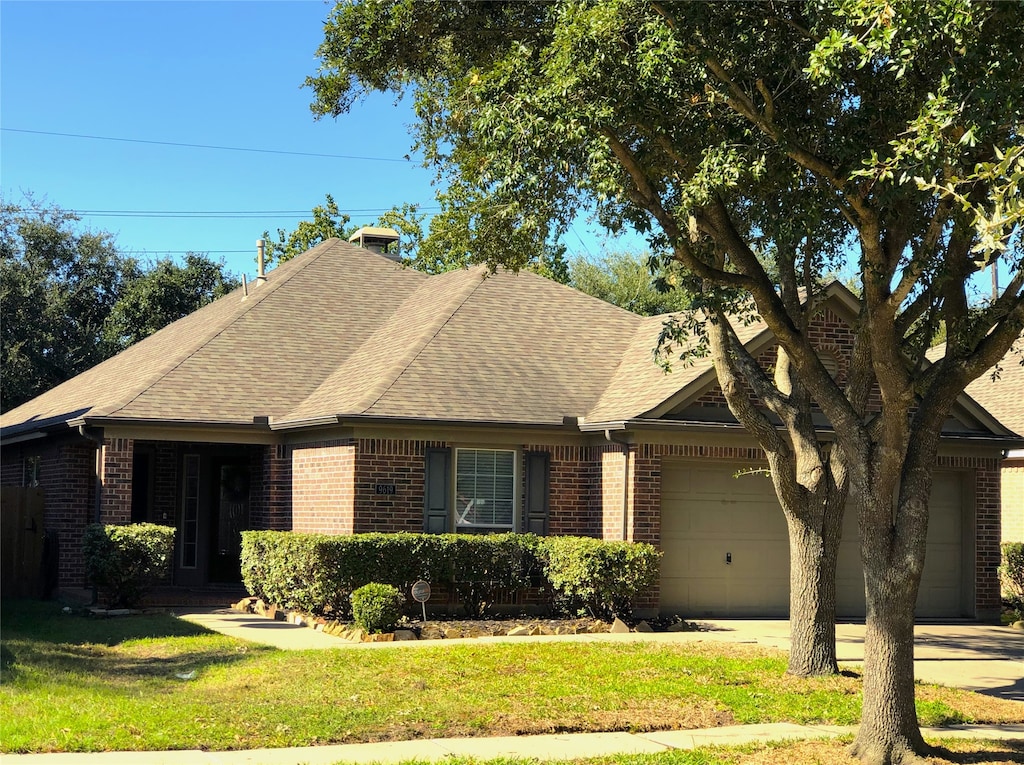 view of front of property with a garage and a front lawn