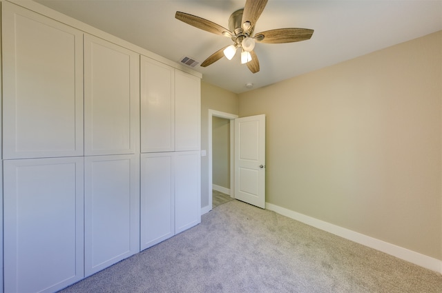 unfurnished bedroom with ceiling fan, a closet, and light carpet