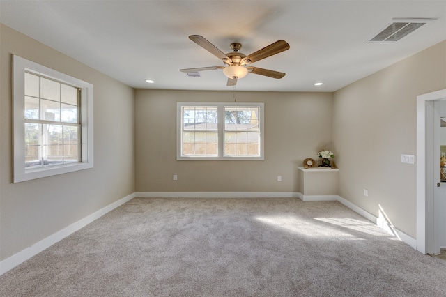 empty room featuring ceiling fan and light colored carpet