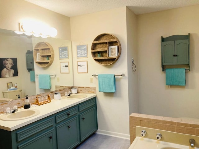 bathroom featuring vanity, a tub, and a textured ceiling