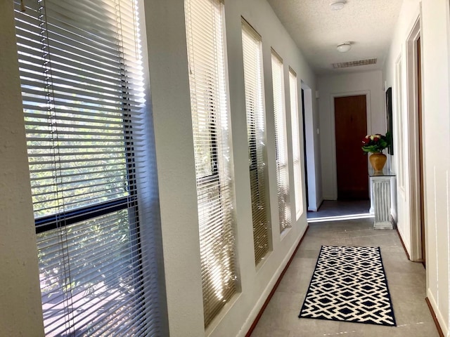 hallway with a textured ceiling