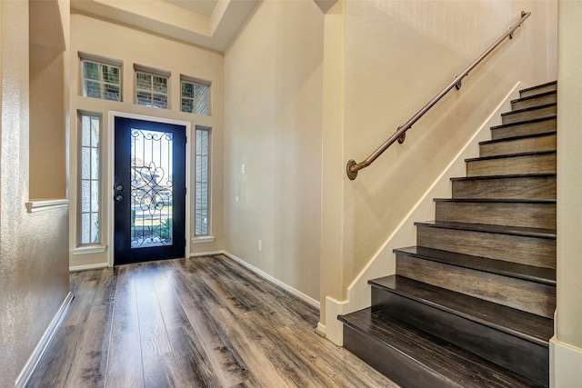 entryway featuring hardwood / wood-style floors and a towering ceiling