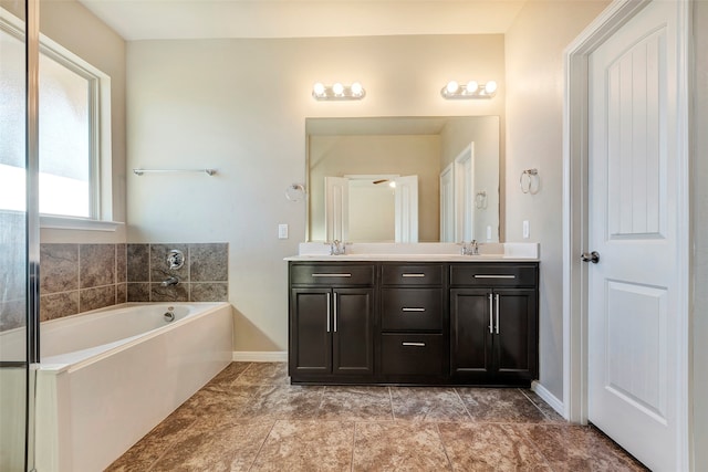 bathroom featuring tile patterned flooring, vanity, and a bath