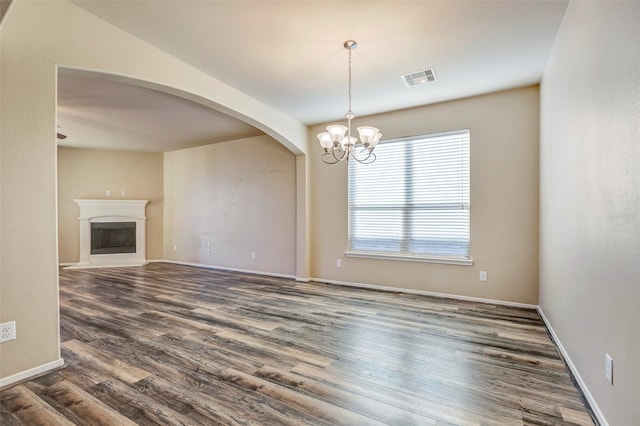 unfurnished living room with dark hardwood / wood-style flooring and an inviting chandelier