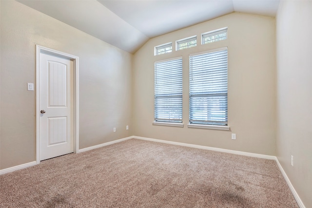 carpeted empty room featuring lofted ceiling