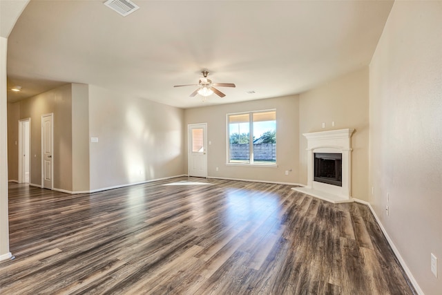 unfurnished living room with dark hardwood / wood-style flooring and ceiling fan