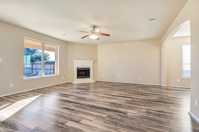 unfurnished living room with ceiling fan and dark hardwood / wood-style flooring