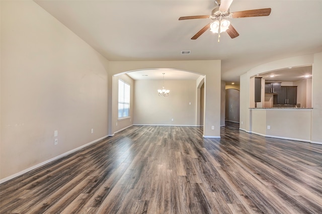 unfurnished living room featuring ceiling fan with notable chandelier and dark wood-type flooring