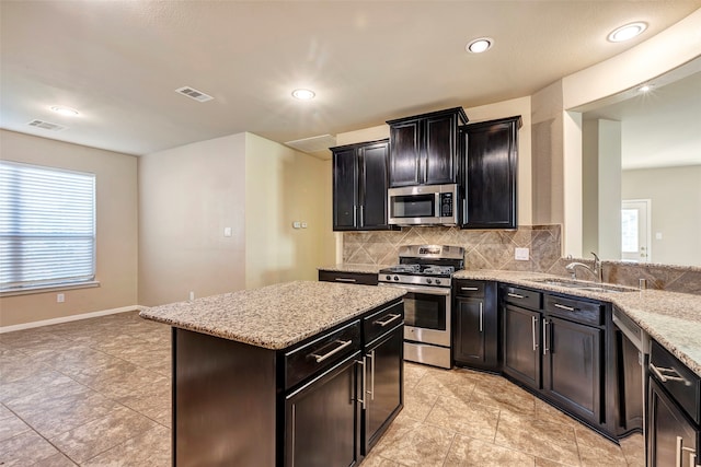 kitchen with a wealth of natural light, decorative backsplash, sink, and appliances with stainless steel finishes