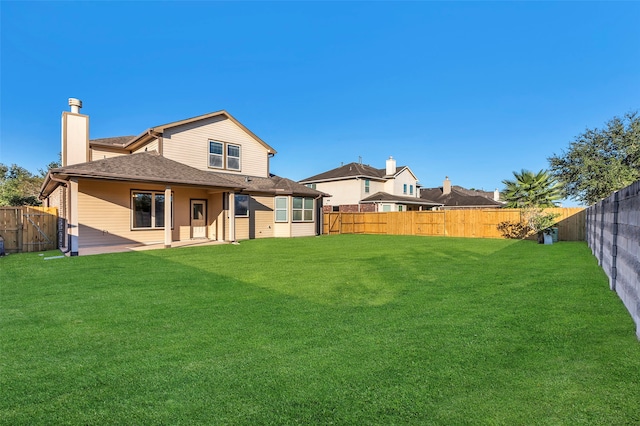 rear view of house featuring a yard