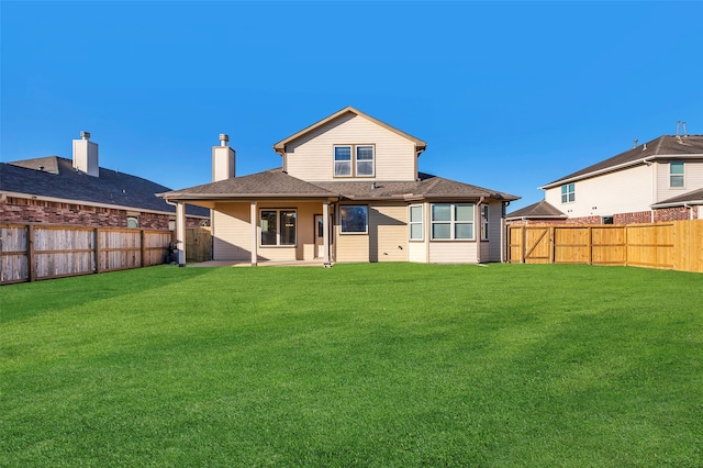 rear view of house featuring a lawn