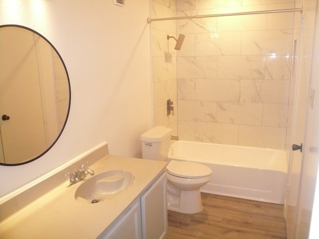 full bathroom with toilet, vanity, wood-type flooring, and tiled shower / bath