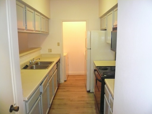 kitchen with sink, light hardwood / wood-style flooring, stainless steel dishwasher, black electric range, and washer / dryer