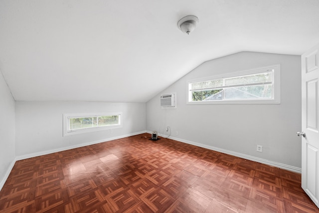 additional living space with dark parquet flooring, plenty of natural light, and vaulted ceiling