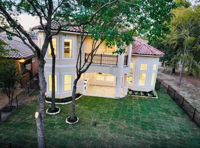 exterior space with a balcony and a lawn