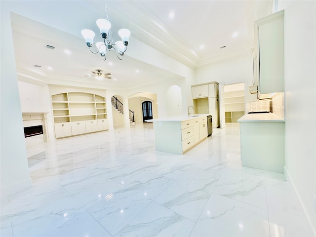 kitchen featuring sink, hanging light fixtures, a kitchen island with sink, ceiling fan with notable chandelier, and ornamental molding