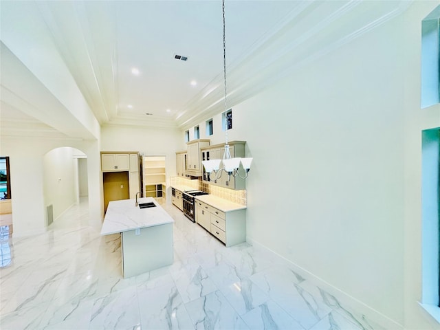 kitchen with backsplash, sink, pendant lighting, stainless steel range oven, and a center island