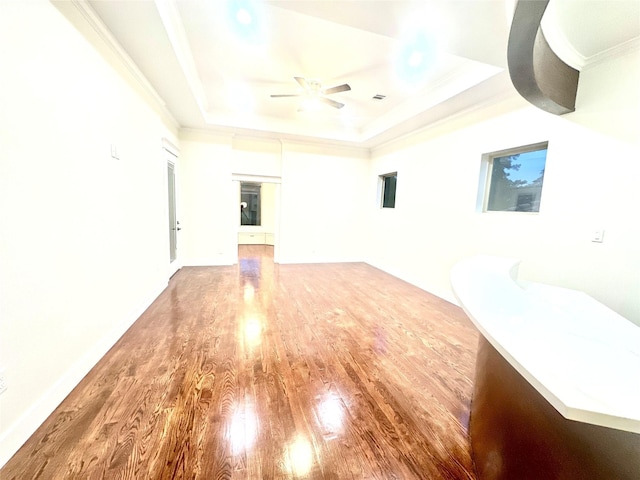 unfurnished room with hardwood / wood-style floors, a raised ceiling, ceiling fan, and crown molding