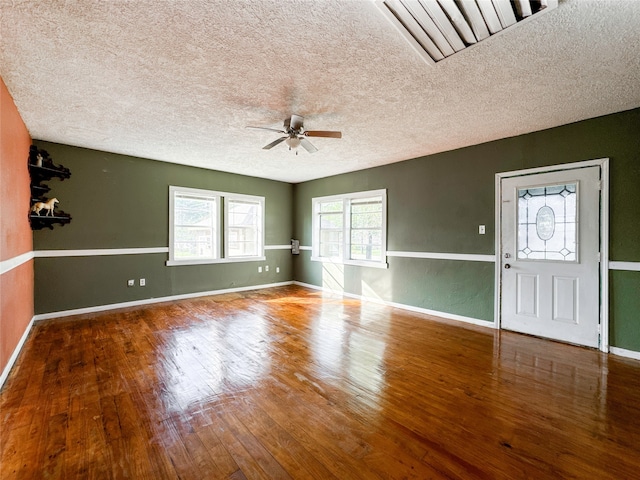 entryway with ceiling fan, a textured ceiling, and hardwood / wood-style flooring