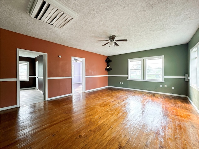 unfurnished room with hardwood / wood-style floors, a textured ceiling, and ceiling fan