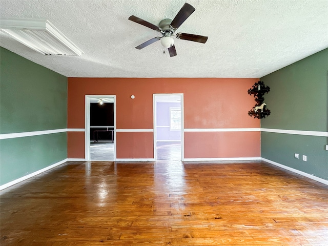 empty room featuring hardwood / wood-style floors, ceiling fan, and a textured ceiling