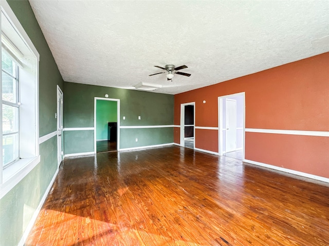 unfurnished room featuring ceiling fan, hardwood / wood-style floors, and a textured ceiling