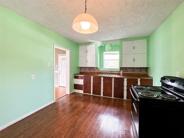 kitchen with sink, black range with electric cooktop, dark hardwood / wood-style floors, a textured ceiling, and decorative light fixtures