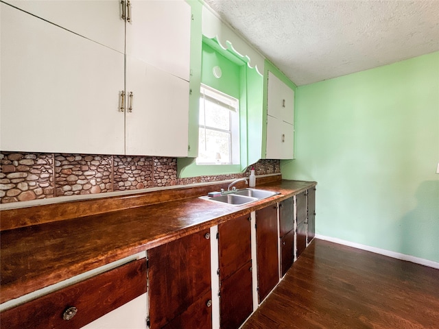 kitchen with a textured ceiling, tasteful backsplash, sink, and dark hardwood / wood-style floors