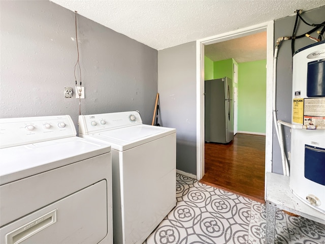 washroom with washer and dryer, a textured ceiling, and light wood-type flooring